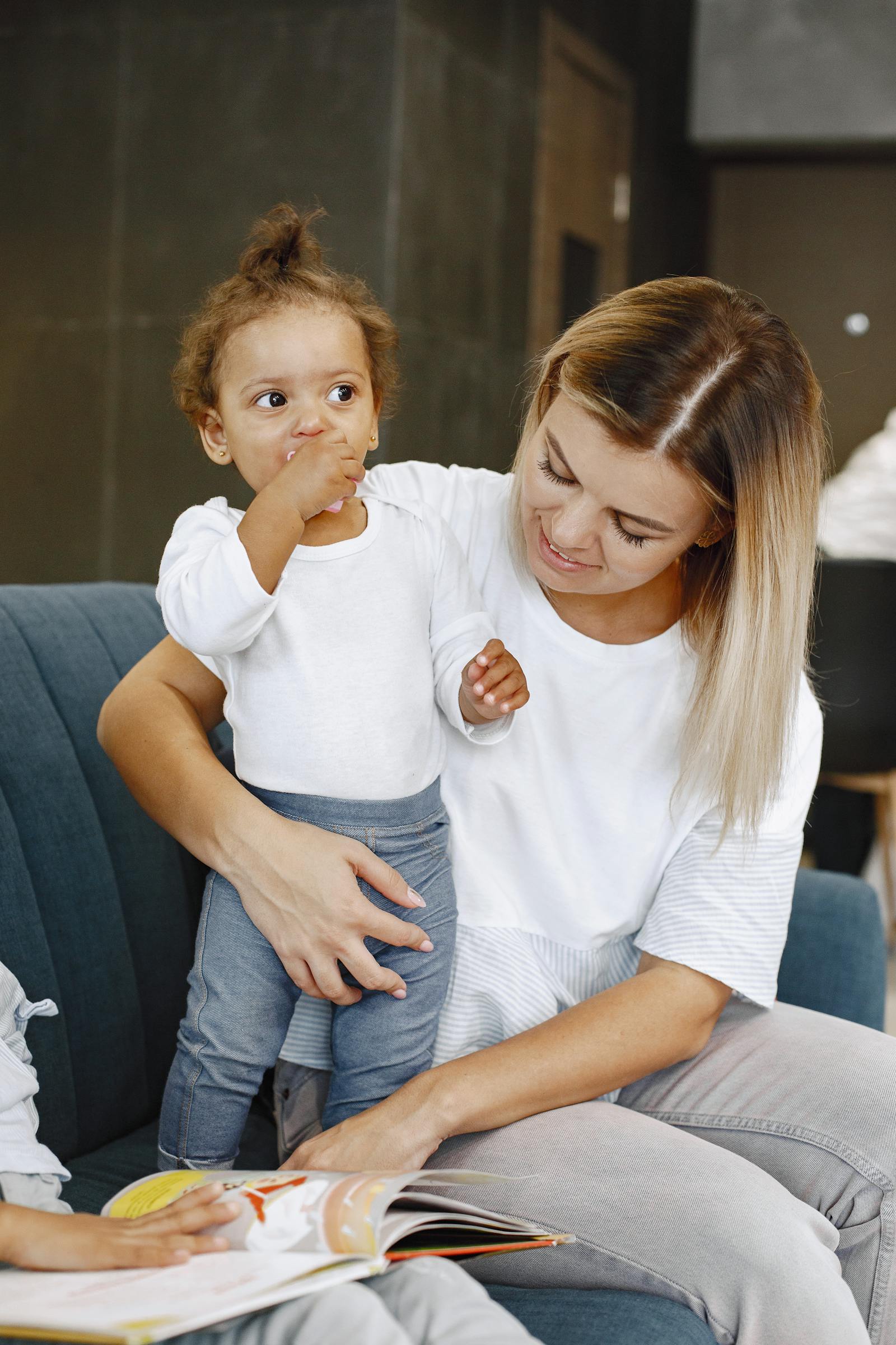 Adulte lisant un livre à un jeune enfant blotti contre lui sur un canapé
