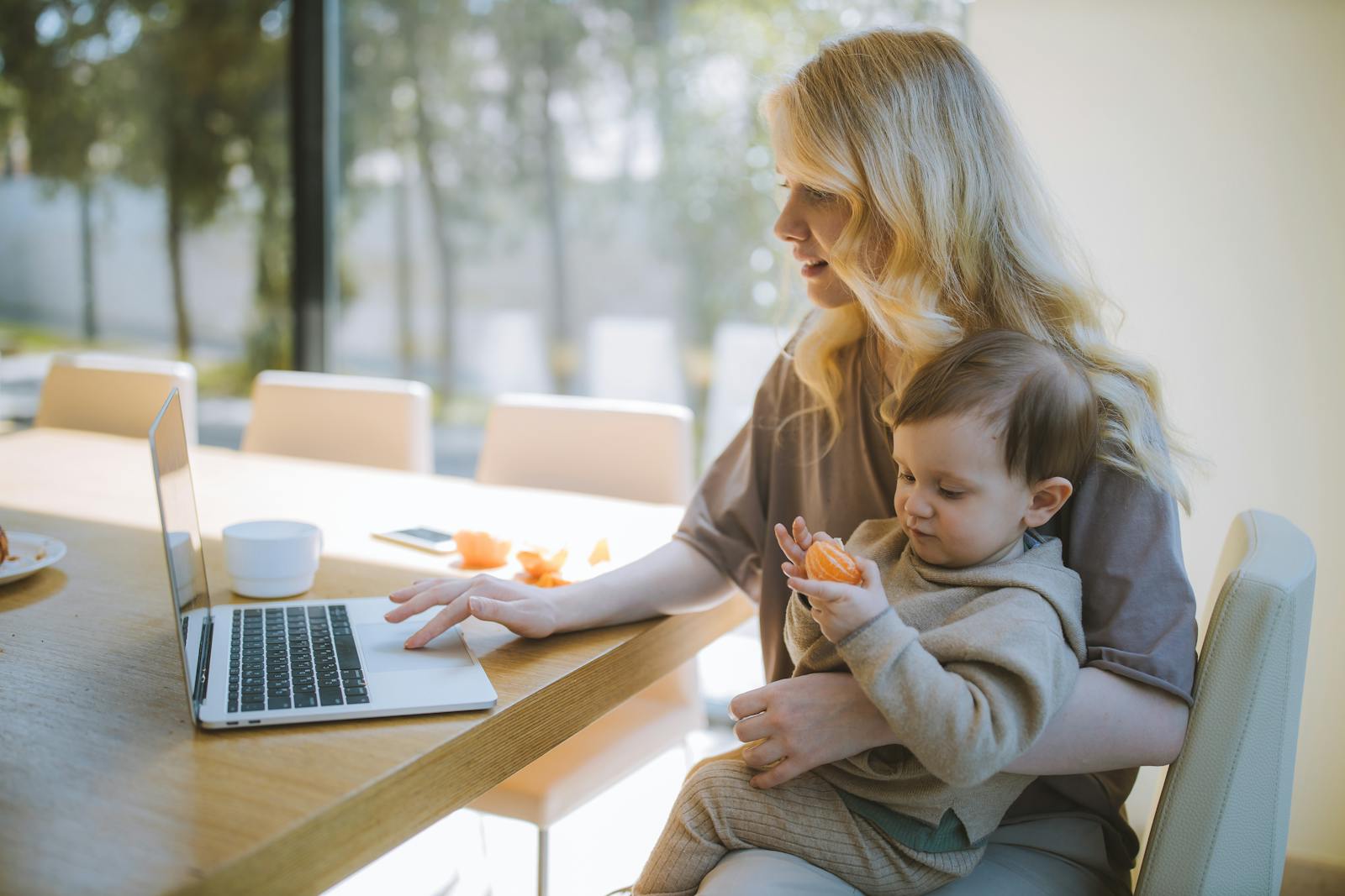 Parent consultant les aides au mode de garde sur un ordinateur portable avec son bébé