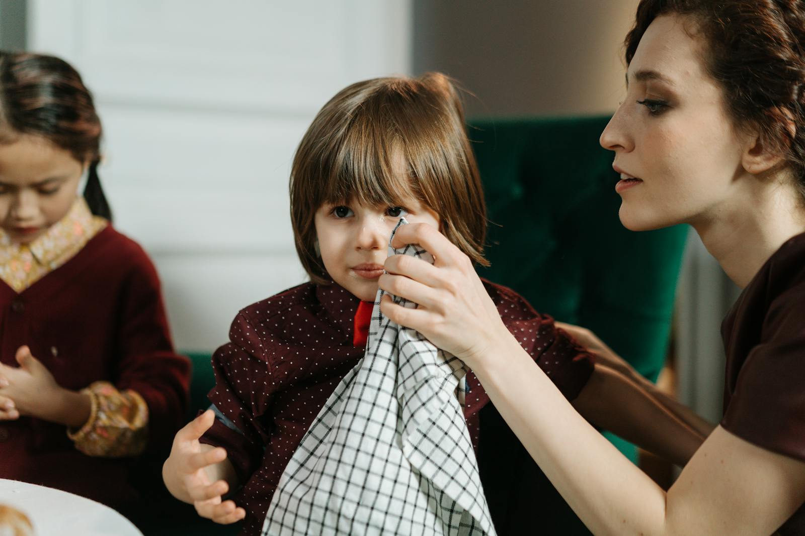 Adulte aidant un jeune enfant pendant le repas, à table dans un cadre familial